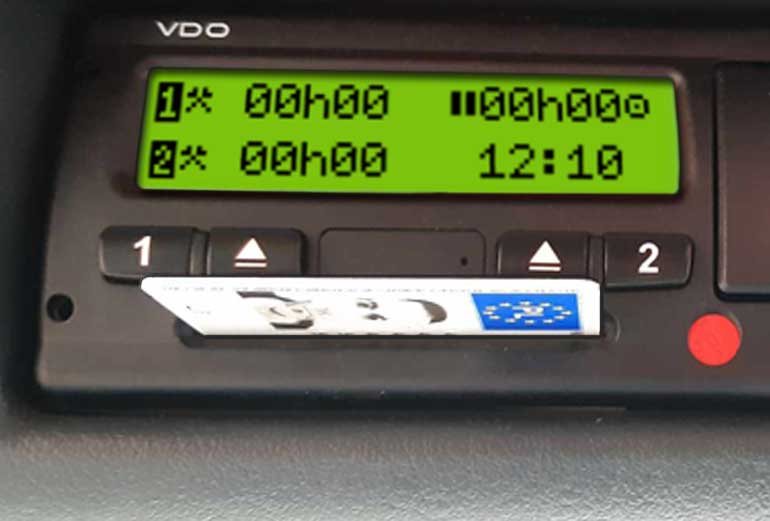 grafika przedstawia urządzenie tachograf z wsuniętą do czytnika kartą kierowcy 