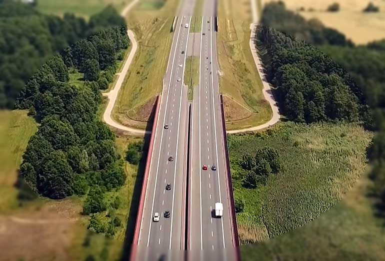 grafika przdstawia autostradę widzianą z lotu ptaka oraz jadące samochody