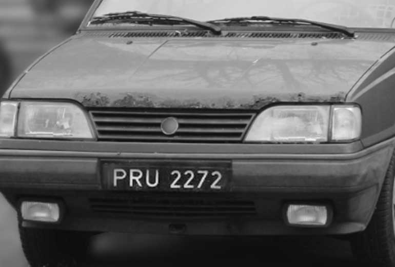 grafika przedstawia stary samochód z czarną rejestracją